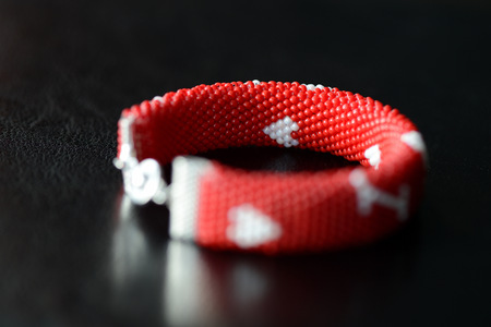 Valentine's Day red beaded bracelet on a dark background close upの写真素材