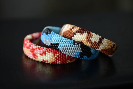 Three camouflage bracelets on a dark background close upの写真素材