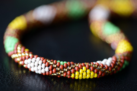 Ethnic style beaded necklace on a dark background close upの写真素材