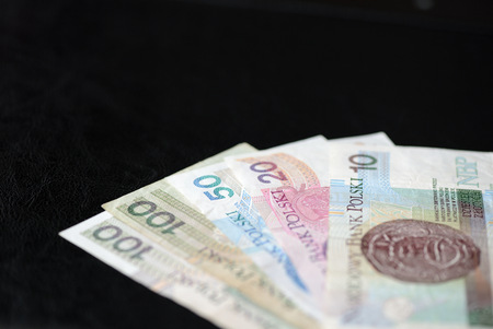 Several banknotes of Polish zloty on a dark background close upの写真素材