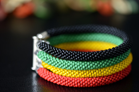 Bead crochet bracelet in Jamaican style on a dark background close upの写真素材