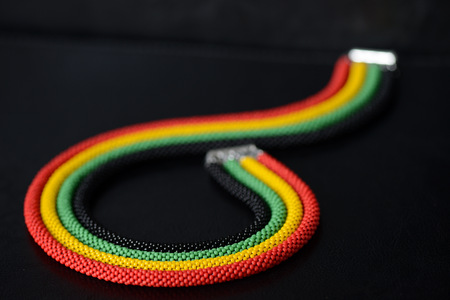 Beaded necklace in Jamaican style on a dark background close upの写真素材