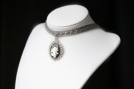 Halloween necklace with skull cameo pendant on a dark background close upの写真素材