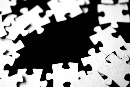 Children's puzzles scattered on a table close up. Black and whiteの写真素材