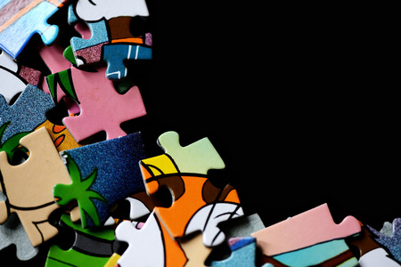 Children's puzzles scattered on a dark background close upの写真素材