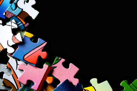 Children's puzzles scattered on a dark background close up