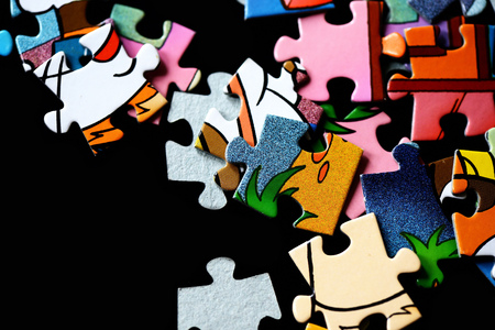 Children's puzzles scattered on a dark background close upの写真素材