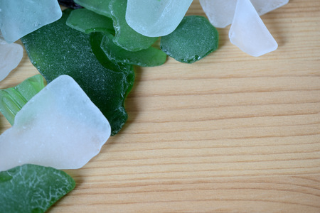 Scattered sea glass on a wooden background close upの写真素材