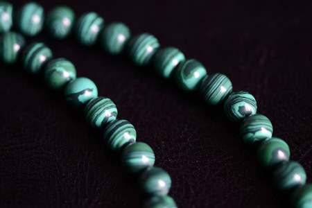 Malachite stone beads necklace on a dark background close upの写真素材
