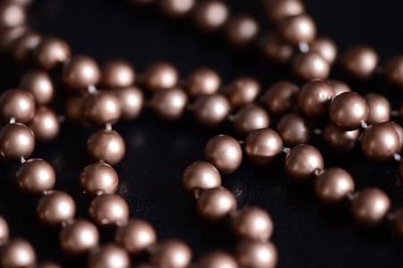 Long necklace of brown beads on a dark background close upの写真素材
