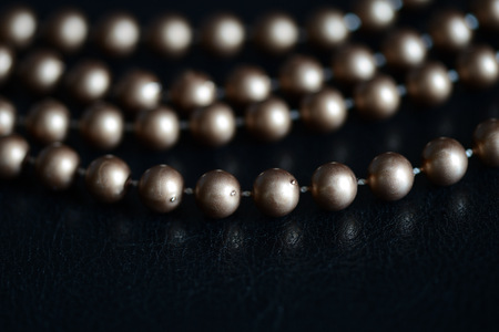 Long necklace of brown beads on a dark background close upの写真素材