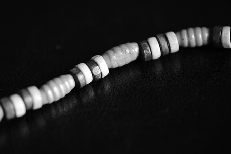 Fragment of a wooden necklace on a dark background close up. Black and whiteの写真素材
