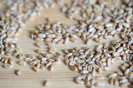Scattered wheat grains on wooden background close upの写真素材