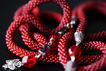 Lariat necklace red color with bead decoration on a dark background close upの写真素材