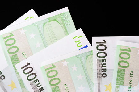 One Hundred euro banknotes on a dark background close up