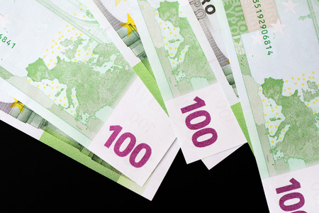 One Hundred euro banknotes on a dark background close up