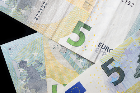 Five euro banknotes on a dark background close up