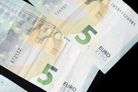 Five euro banknotes on a dark background close up