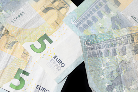 Five euro banknotes on a dark background close up