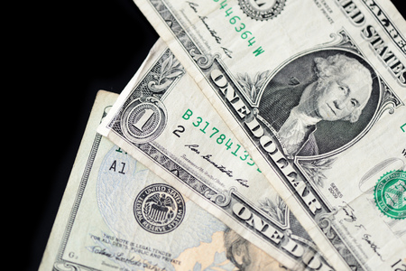 A few dollar bills on dark background close up