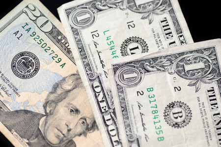 A few dollar bills on dark background close up