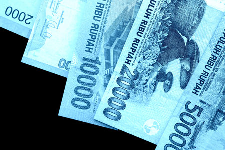 Several Indonesian rupiah banknotes close up. Blue color toned