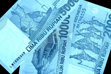 Several Indonesian rupiah banknotes close up. Blue color tonedの写真素材