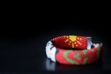 Red bracelet with funny panda on a dark background close upの写真素材