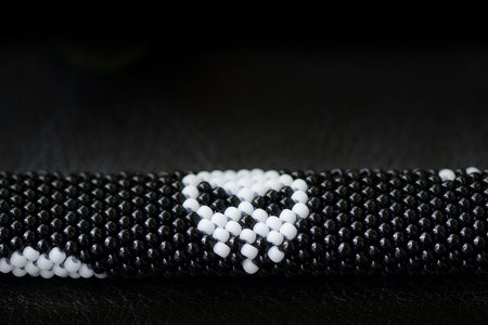 Black beaded bracelet with skull image on a dark background close upの写真素材