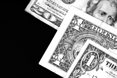 One and twenty dollar bills on a dark background close up in monochromeの写真素材