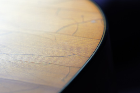 Old acoustic guitar with cracks on the soundboard close upの写真素材