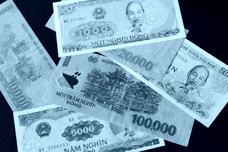 Vietnamese dongs on a dark background close up. Blue color tonedの写真素材
