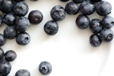 Fresh blueberry berries on a white plate close up. Top viewの写真素材