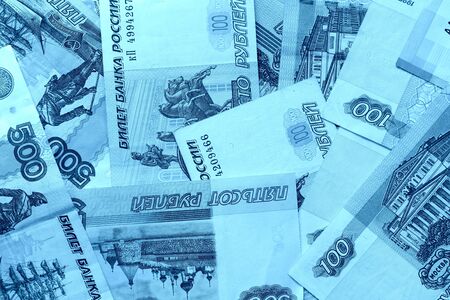 Different bills of Russian rubles close up. Money background blue color toned