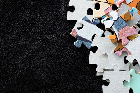 Children's puzzles scattered on a dark surface close-upの写真素材