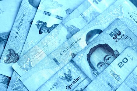 Various banknotes thai baht close up. Money background blue color tonedの写真素材
