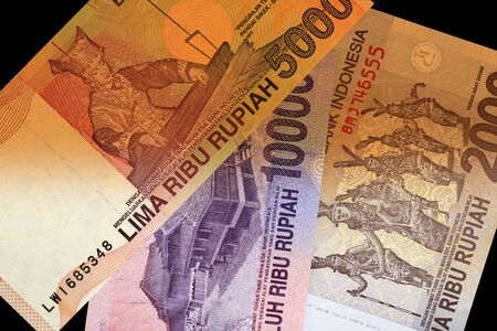Several Indonesian rupiah close up. Money background brown color toned