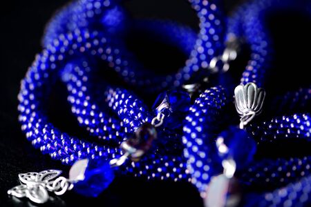 Long open necklace (lariat) blue color on a dark background close upの写真素材