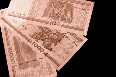 Outdated Belarusian rubles on black background close up brown color toned