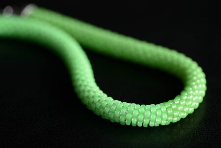 Beaded necklace light green color on a dark background close upの写真素材
