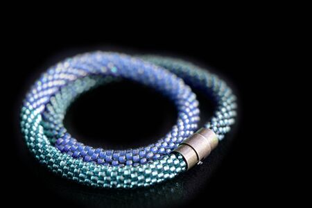 Beaded necklace three shades of blue on a dark background close upの写真素材