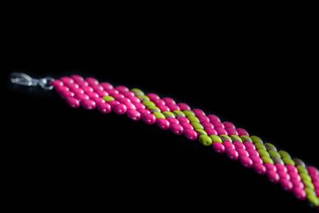 Beaded bracelet bright pink color on a dark background close upの写真素材