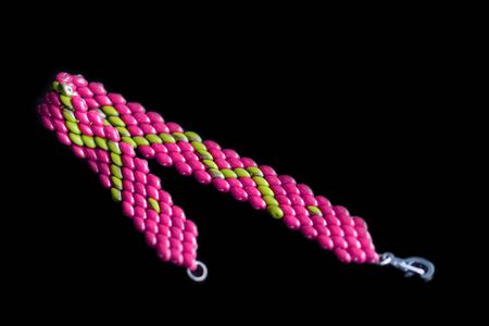 Beaded bracelet bright pink color on a dark background close upの写真素材