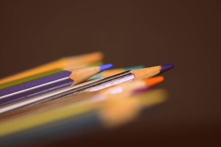 Colored pencils on a dark background close up. Retro style