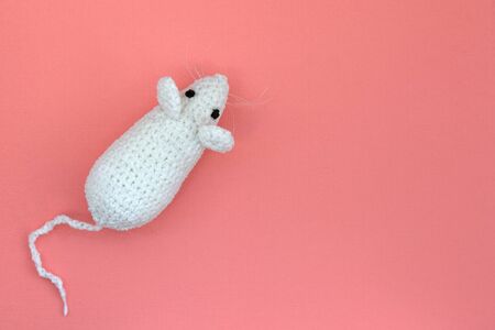 White crocheted rat on a pink background. Mouse symbol 2020 new year. Top view, copy spaceの写真素材
