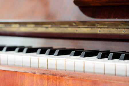 Old brown piano close-up. The keys of an old vintage pianoの写真素材