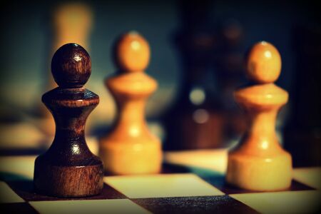 Wooden chess figures on a chessboard close up