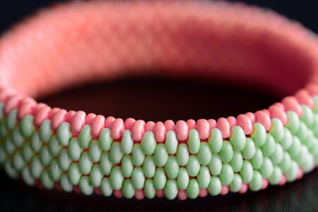 Bangle bracelet made of twin beads on a dark background close-up