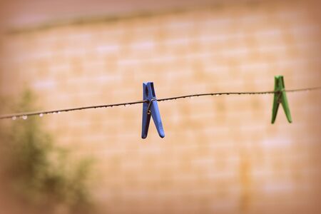 Plastic clothespins on wet wire after rain in the backyard close-up. Retro styleの写真素材
