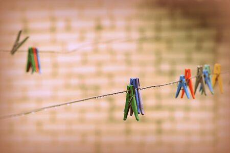 Plastic clothespins on wet wire after rain in the backyard close-up